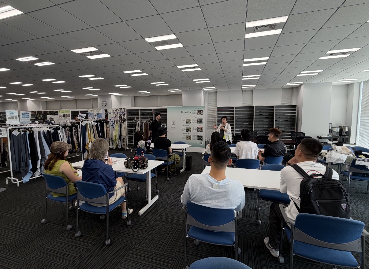 商品や販売活動について参加者が説明を聞く様子